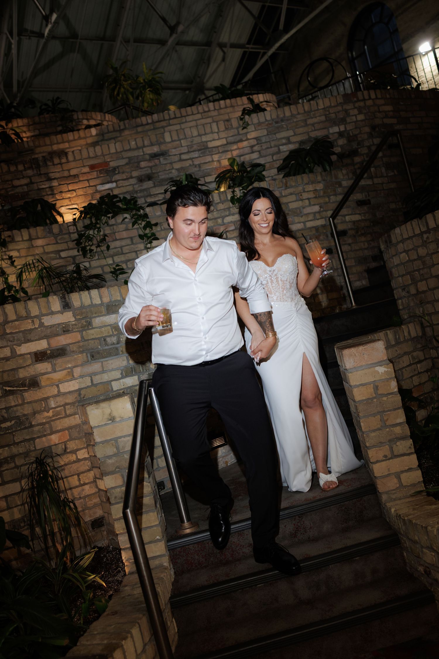 Candid moments of a couple on a rustic brick staircase in casual wedding attire.