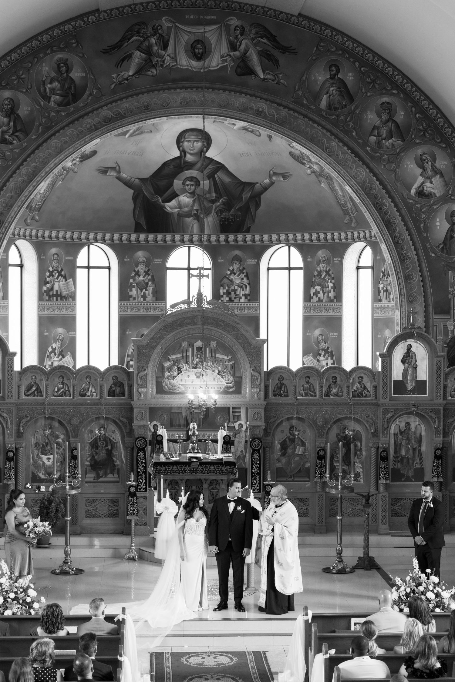 Orthodox church wedding ceremony with beautiful iconography and natural light streaming through windows.