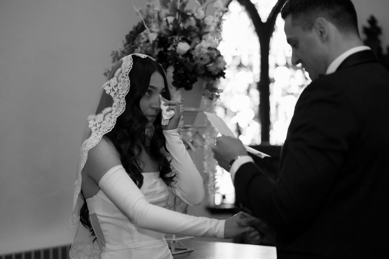 Wedding couple shares first dance in dimly lit reception space.