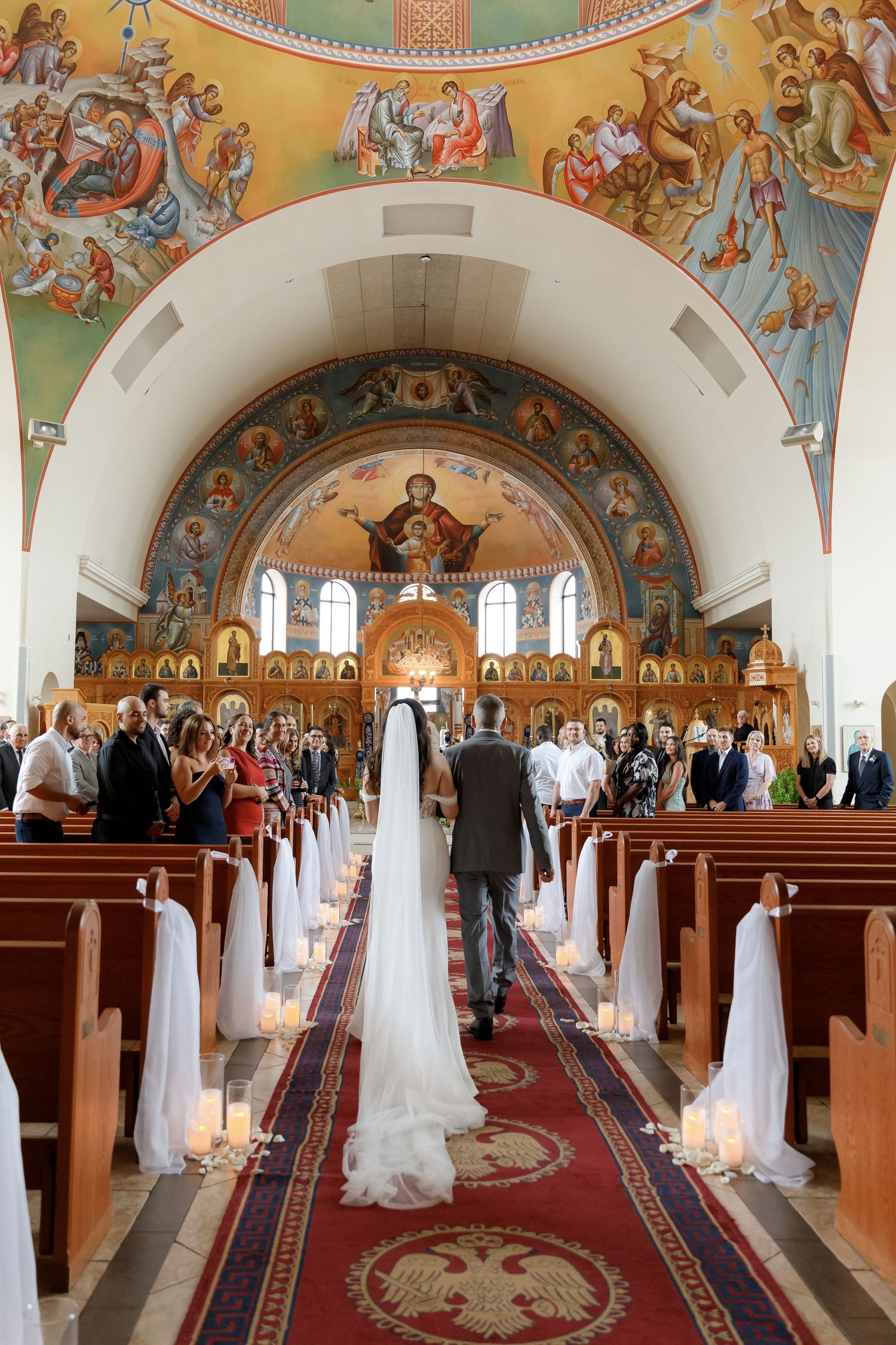 Ornate Orthodox church interior with beautiful frescoed ceiling and traditional wooden pews.
