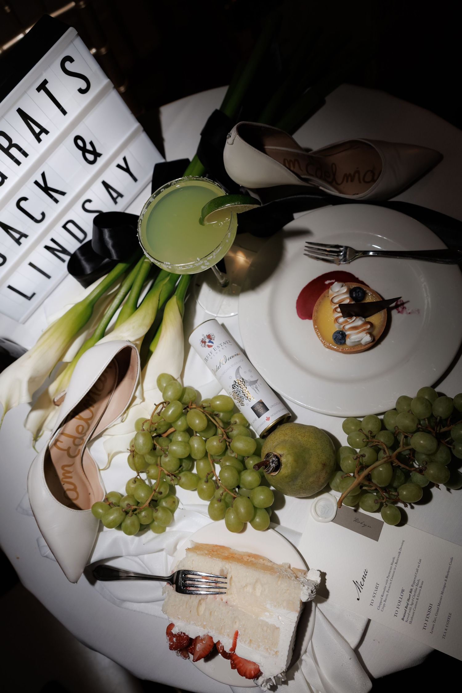 Artistic overhead shot of wedding reception table with grapes and place settings.