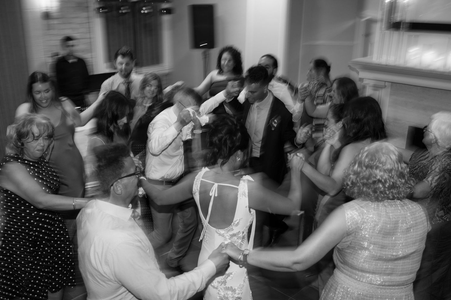 Wedding reception guests dancing and celebrating on a crowded dance floor.
