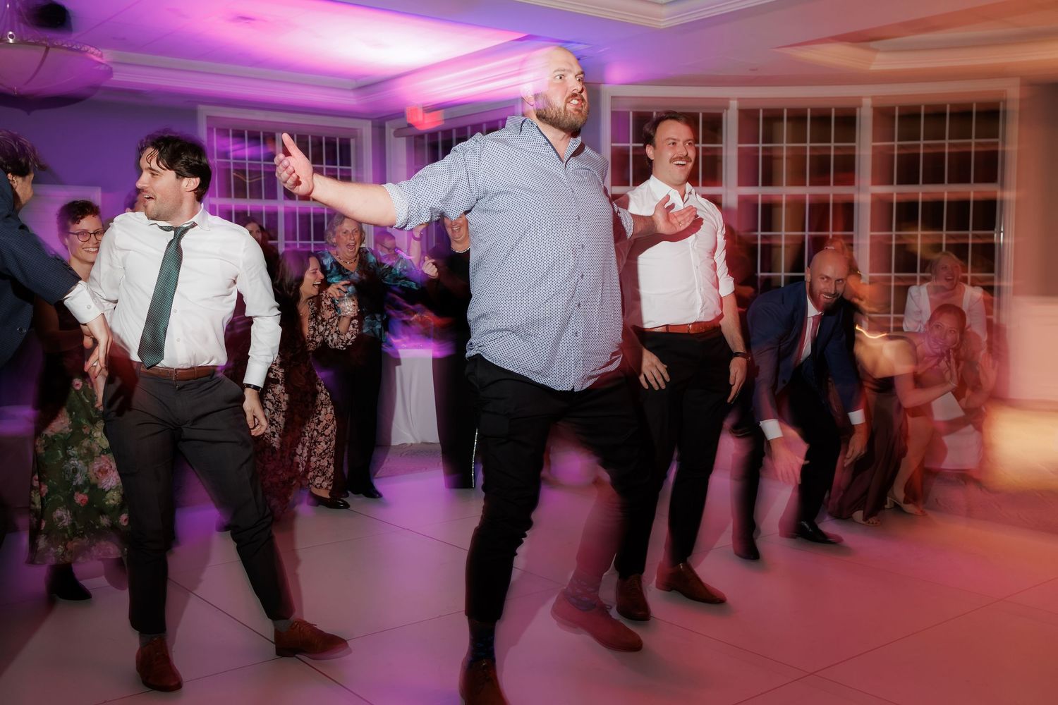 Wedding guests performing a coordinated line dance at the reception.