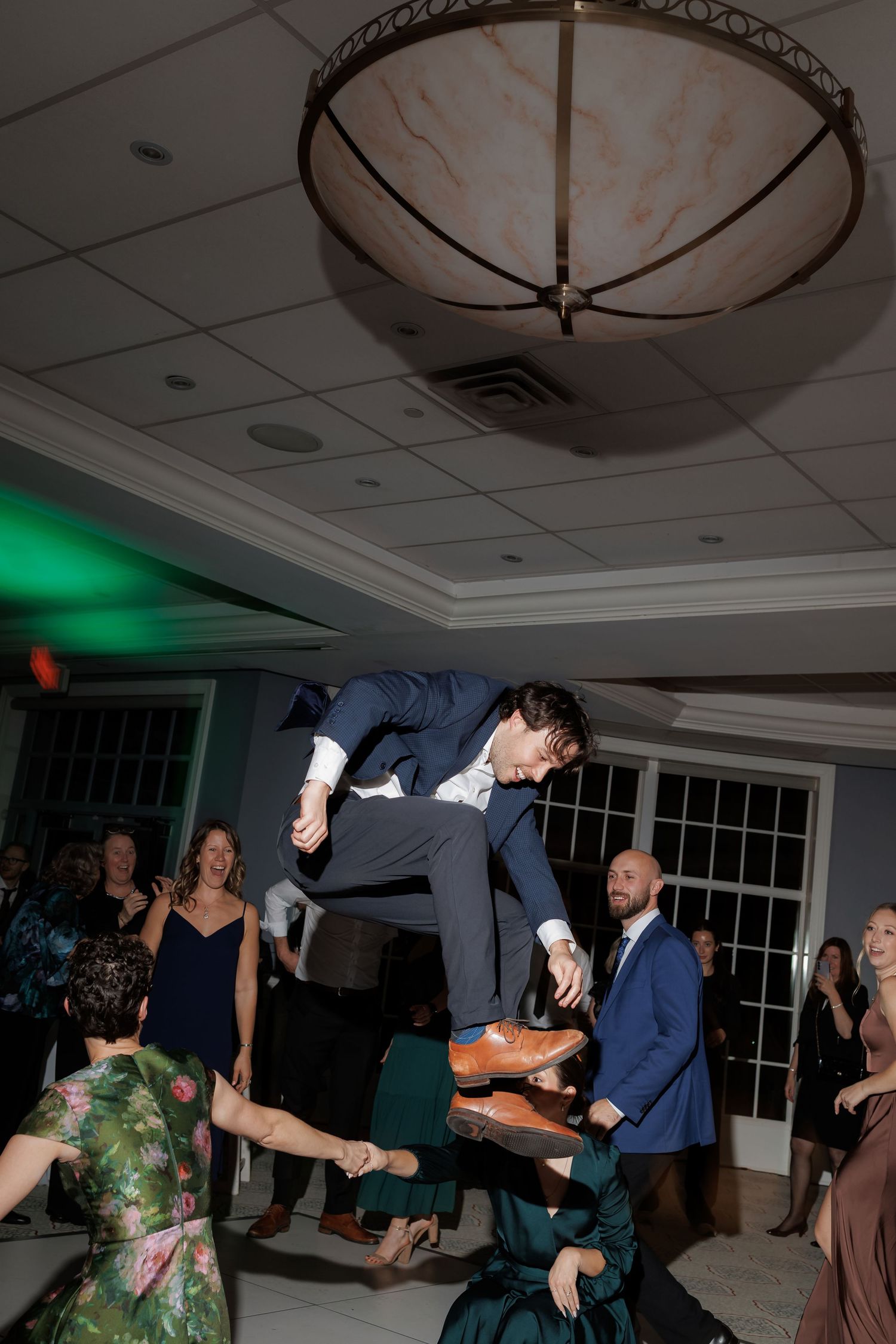 Guests dancing and jumping during lively wedding reception celebration.