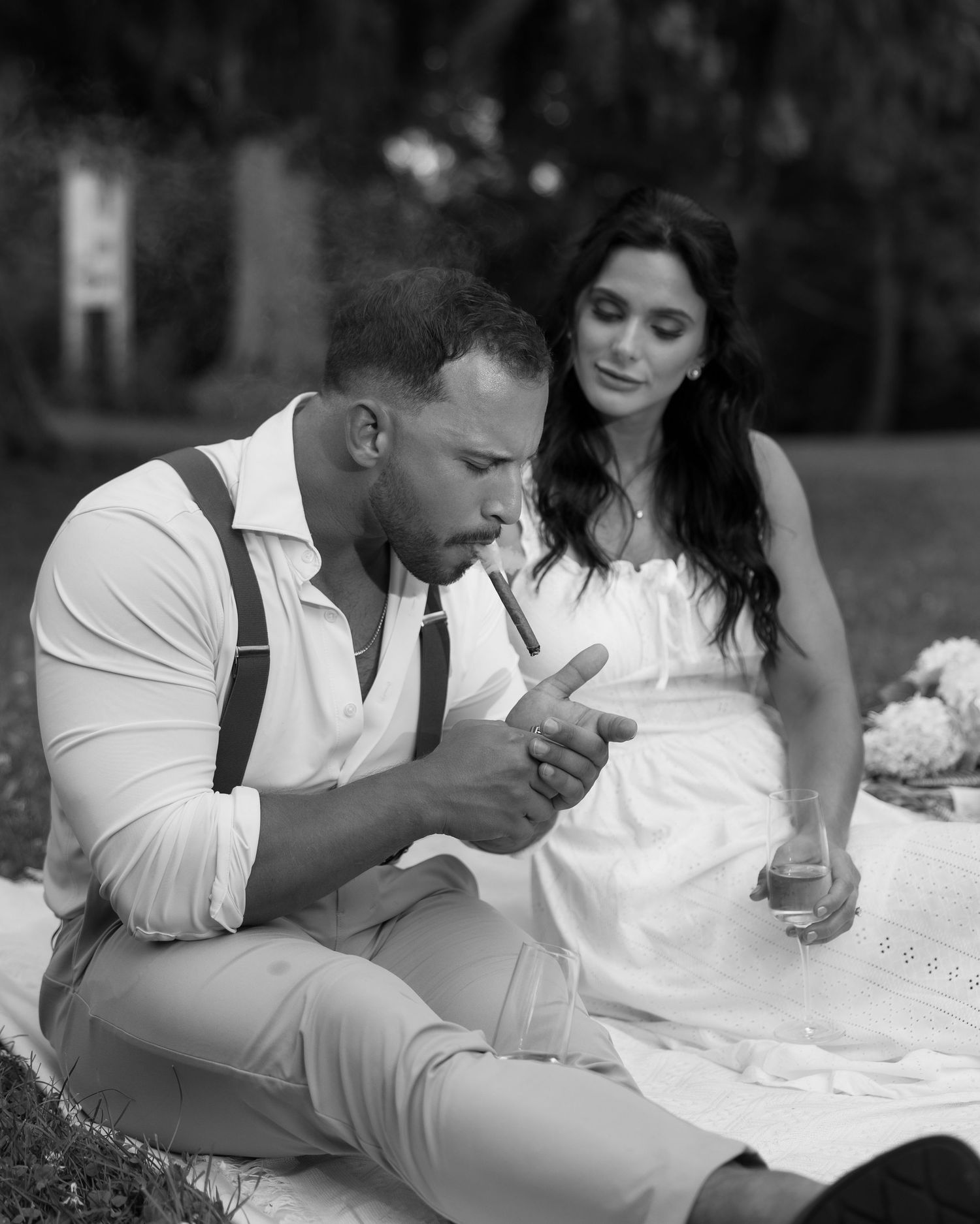 Black and white photo of couple sharing intimate moment while eating outdoors.