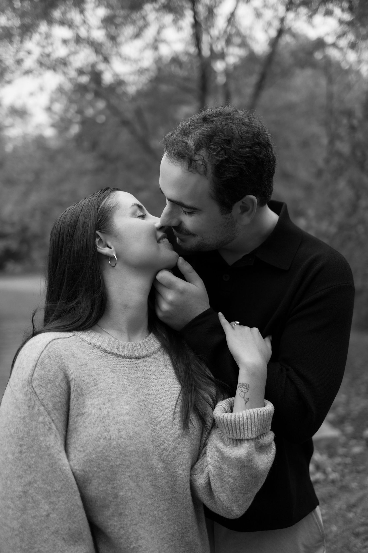 A couple in black and gray share a romantic kiss sequence outdoors in a black and white photo series.