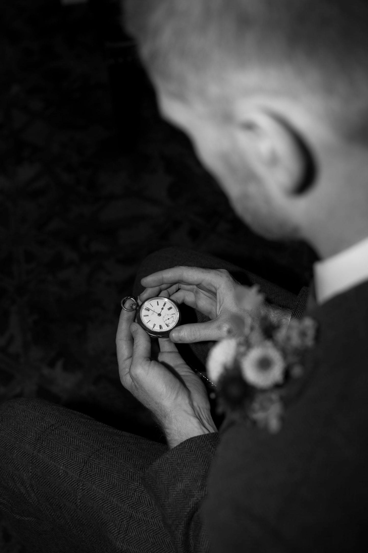 Close-up shot of pocket watch being held in dramatic black and white.
