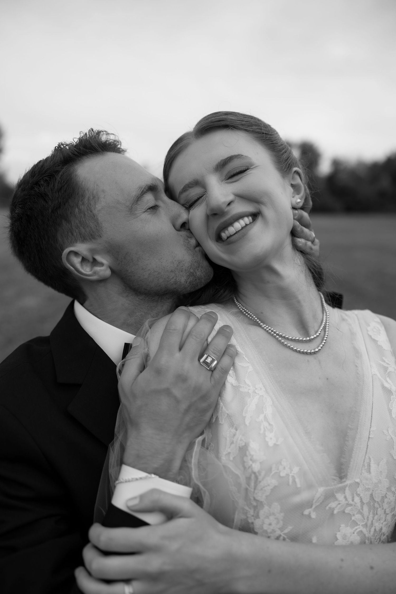 Intimate black and white wedding portrait showing tender moment between newlyweds.