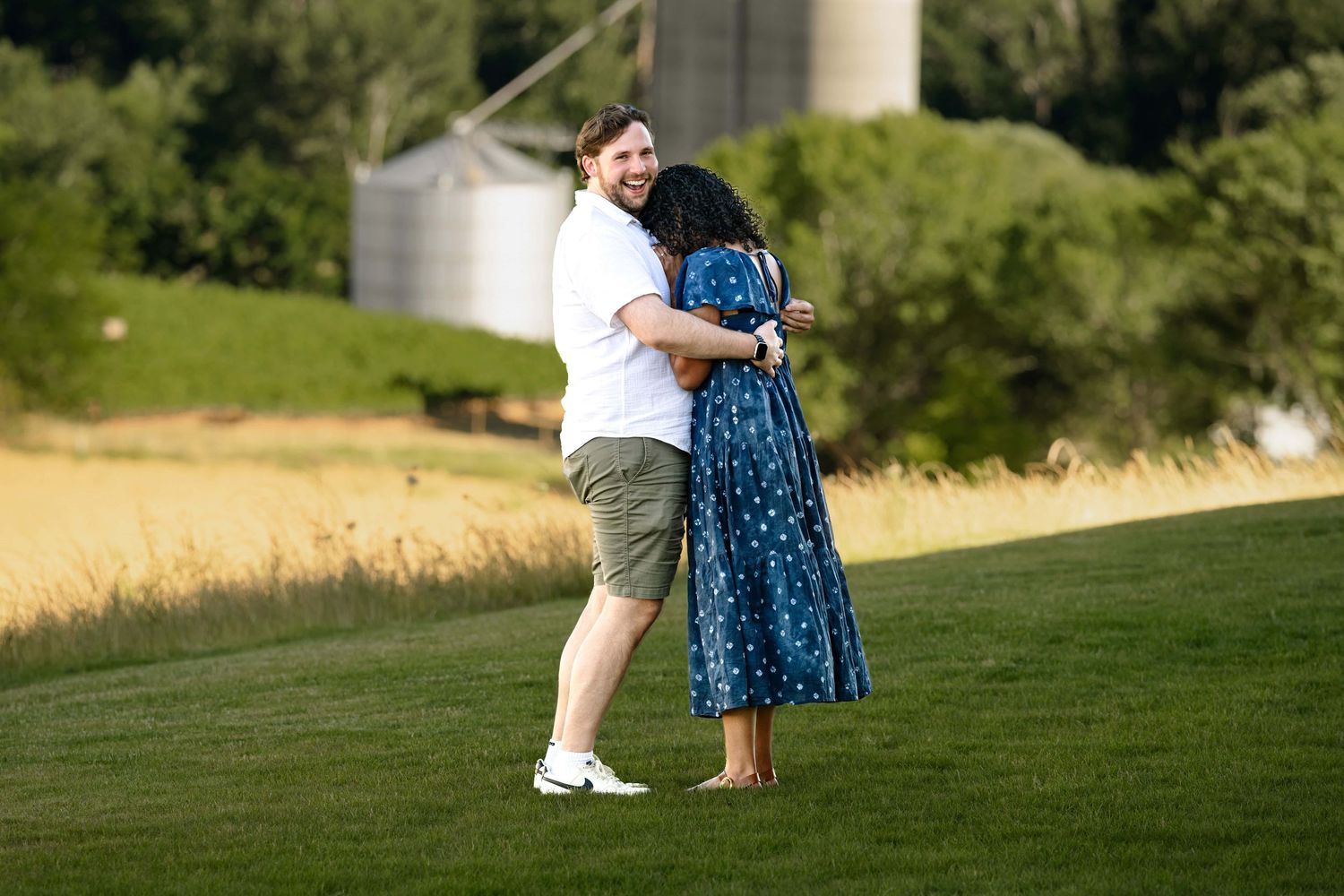 A man looks over at the proposal photographer just after proposing as he embraces his partner.