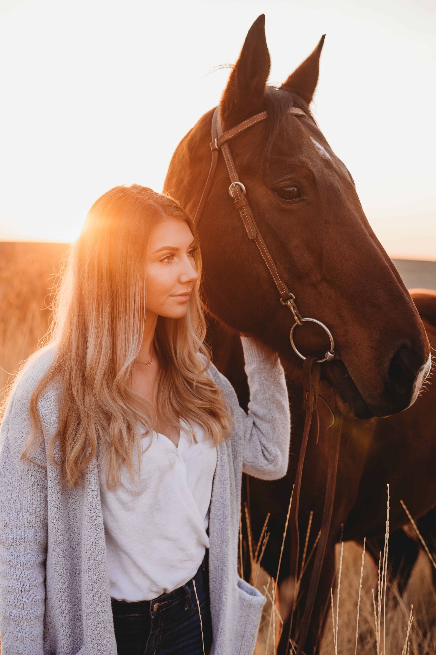 A portrait of a senior and her horse, looking away from the camera with a soft expression on her face in Walla Walla.