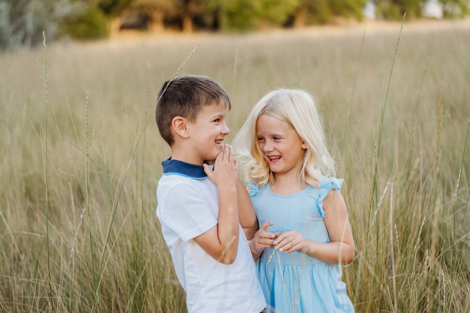 A portrait of twin children laughing at each other at Whitman Mission in Walla Walla.