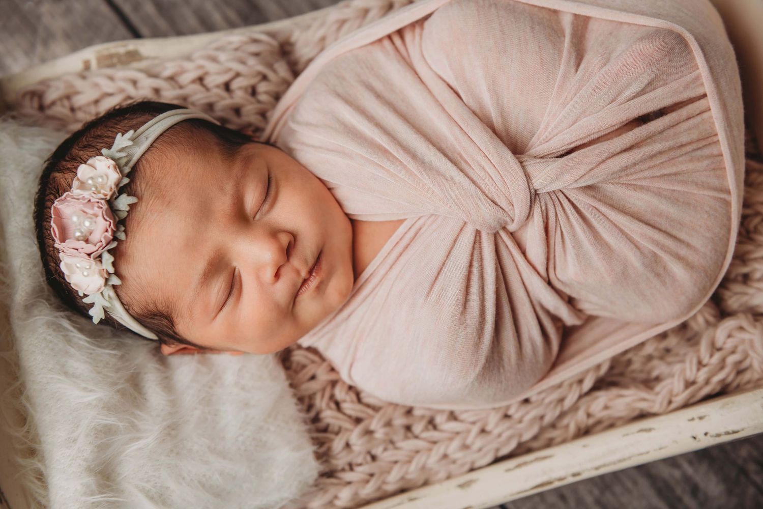 Newborn photography in Walla Walla featuring a sleeping baby wrapped in soft fabric during a studio session.