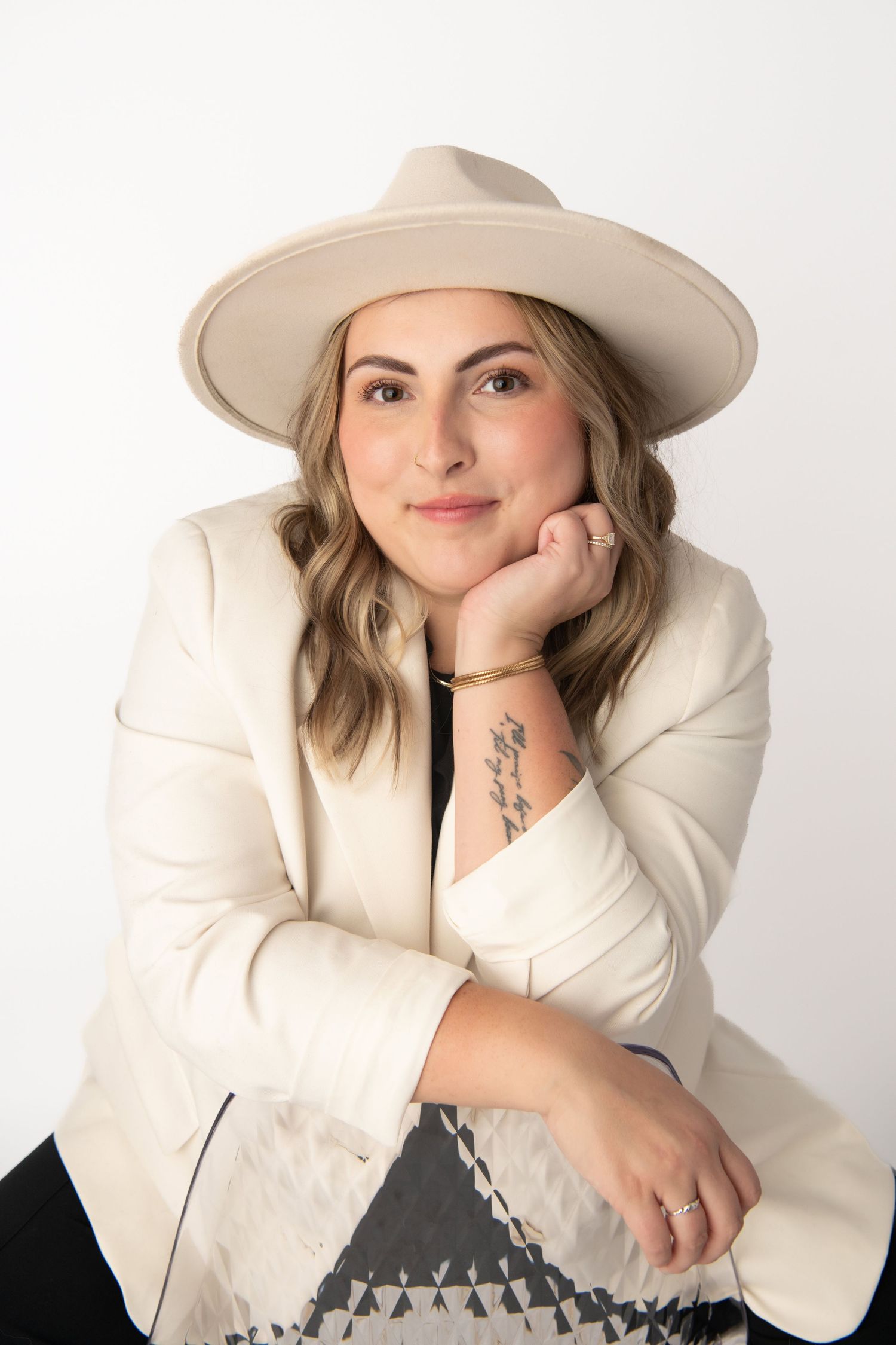 A woman wearing a hat in a relaxed pose for a professional headshot image