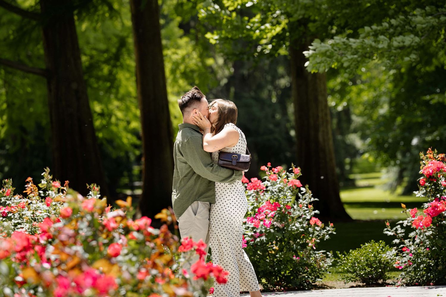 A couple kissing in a beautiful green, lush park in Walla Walla.
