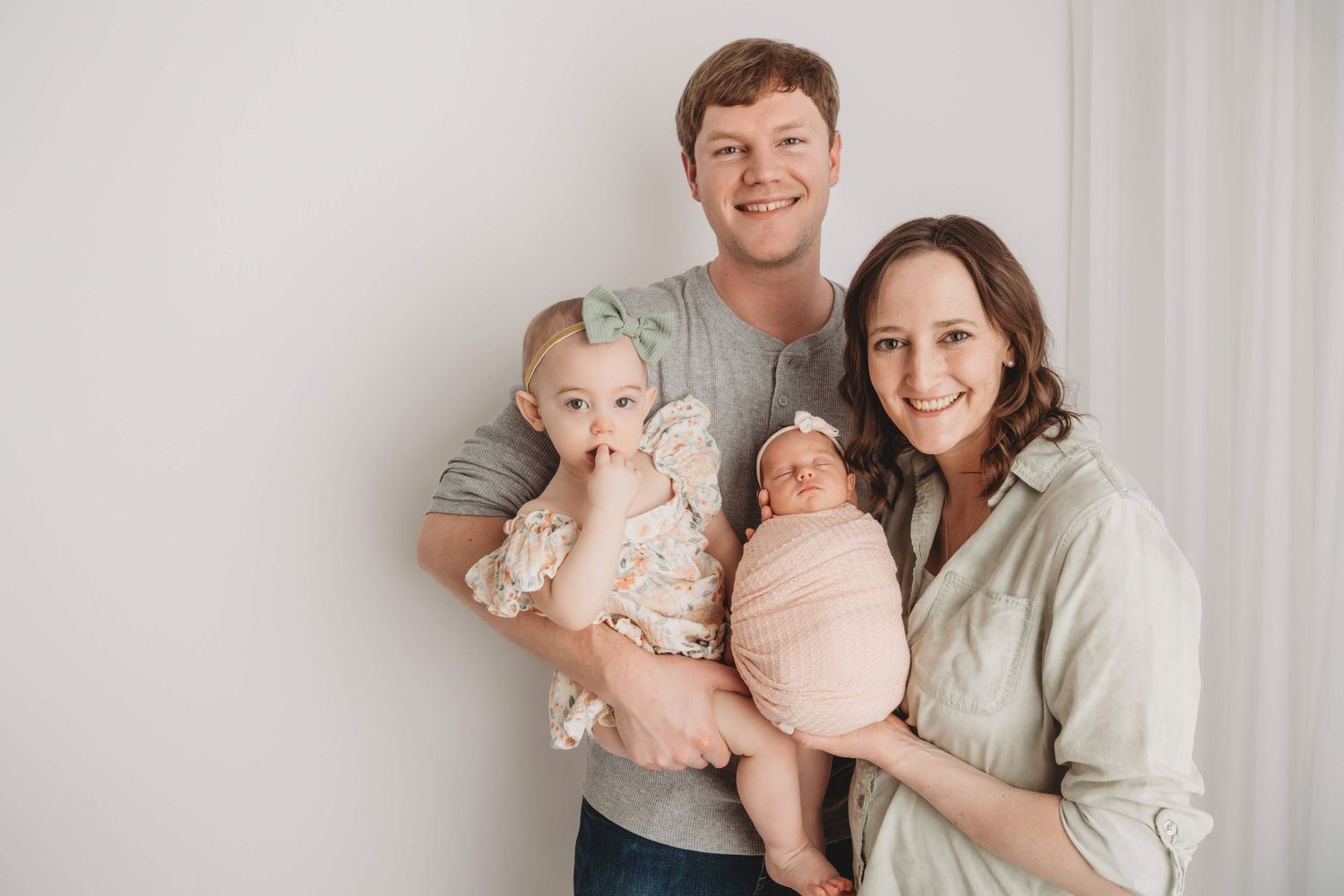 Family portrait in a Walla Walla studio with their newborn dressed in pastel colors.