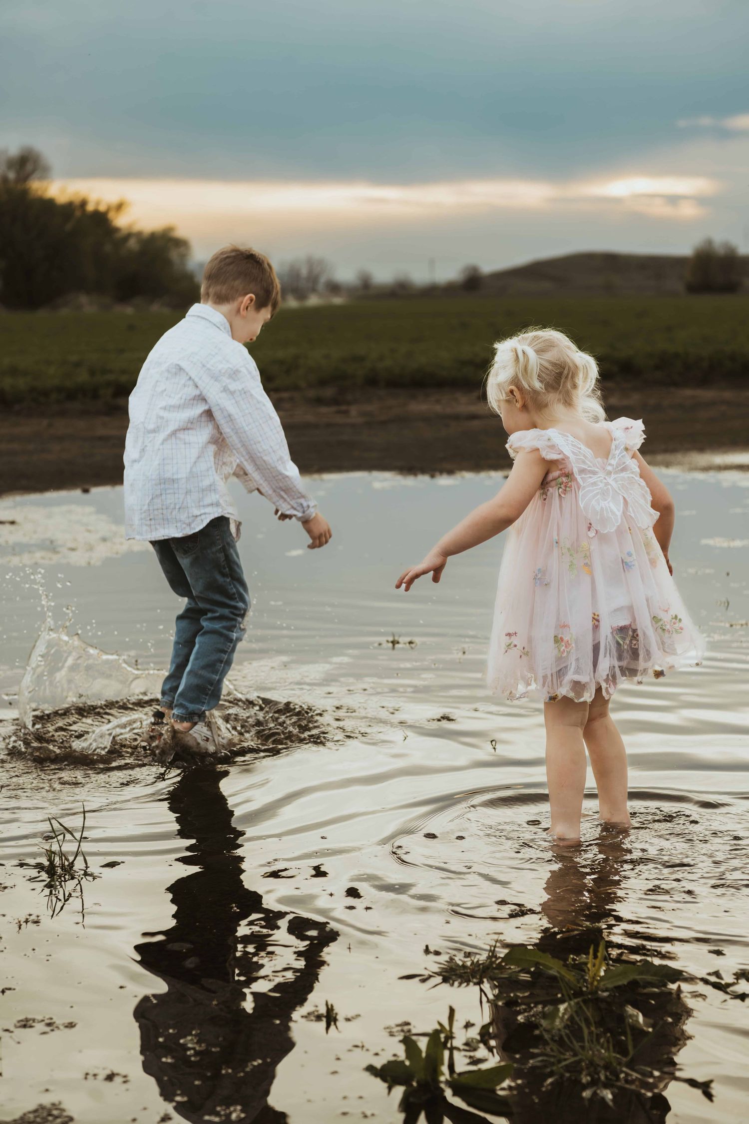 Two children jumping in a puddle during sunset captured by a Walla Walla photographer.
