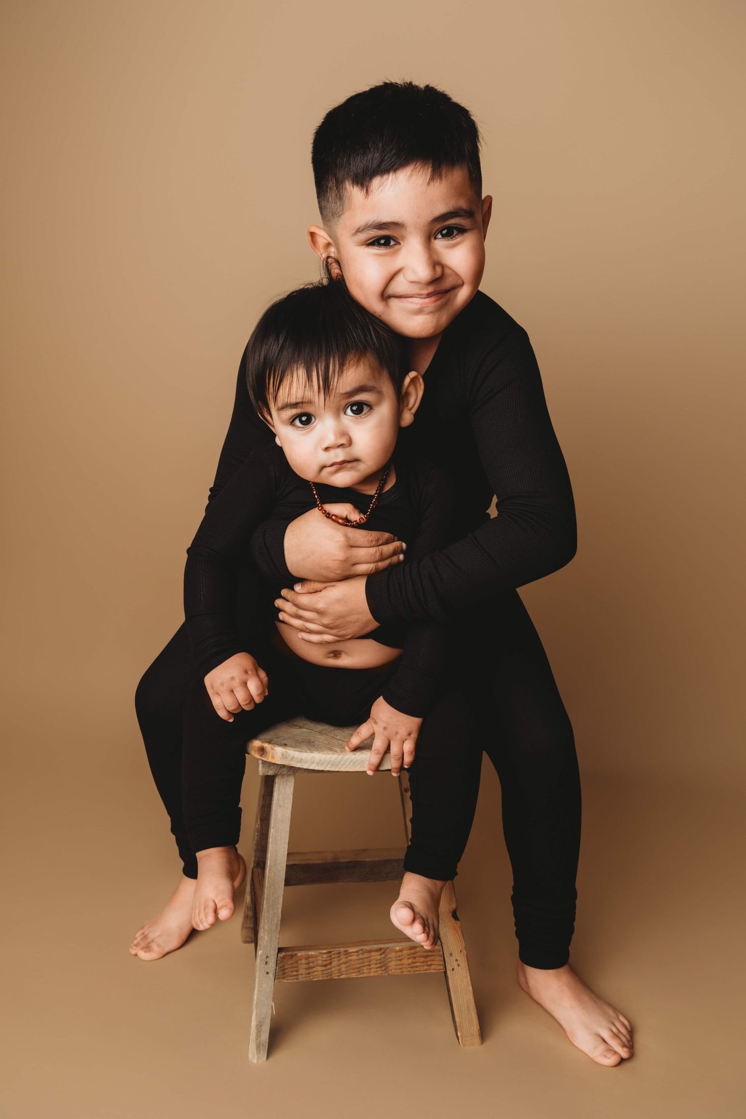 Two brothers sit on a stool for a portrait at a Walla Walla photography studio.