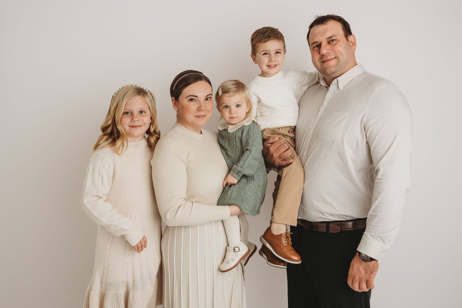 A family of five smiling for a studio portrait in Walla Walla.