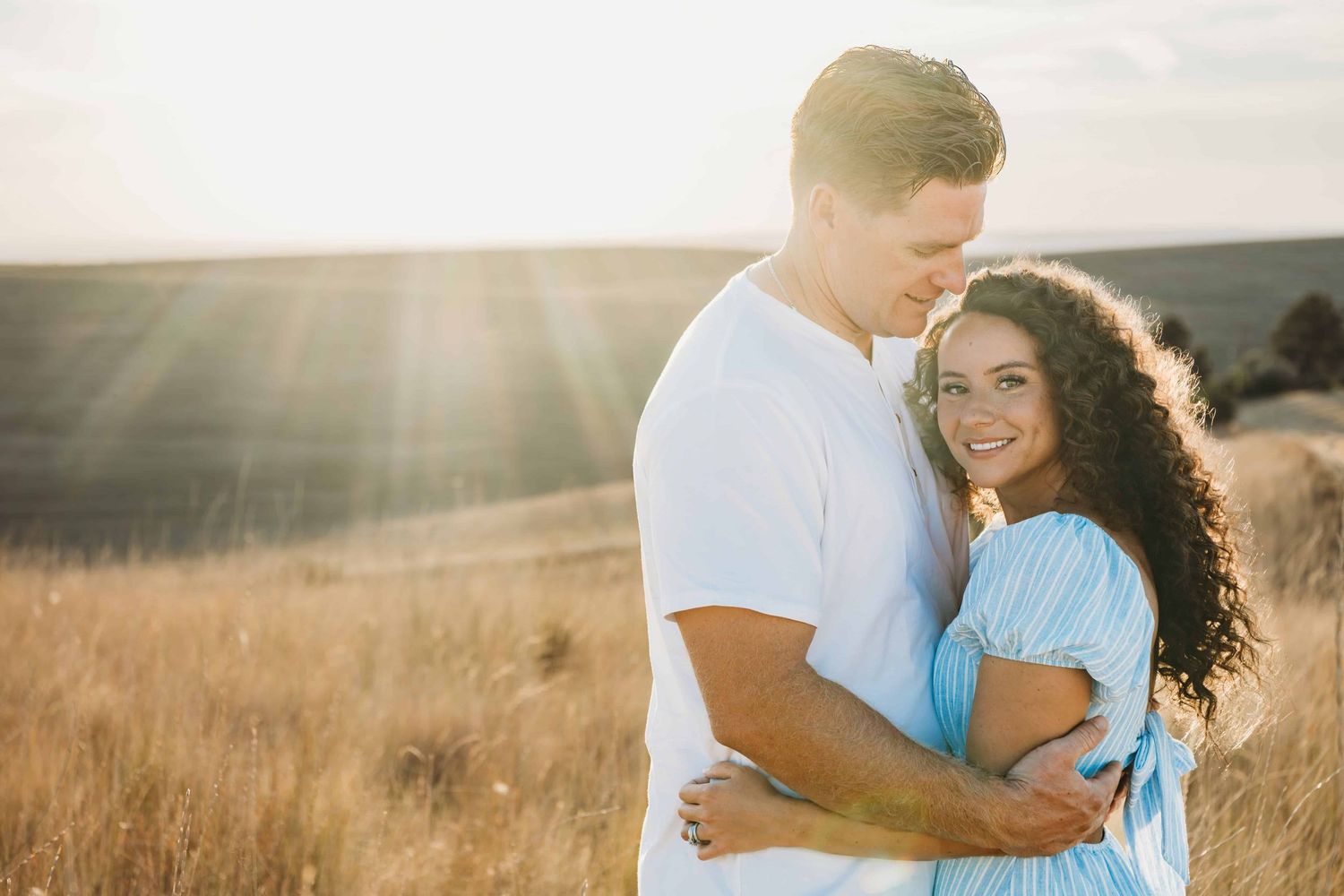 A couple hugging with golden light shining on them.