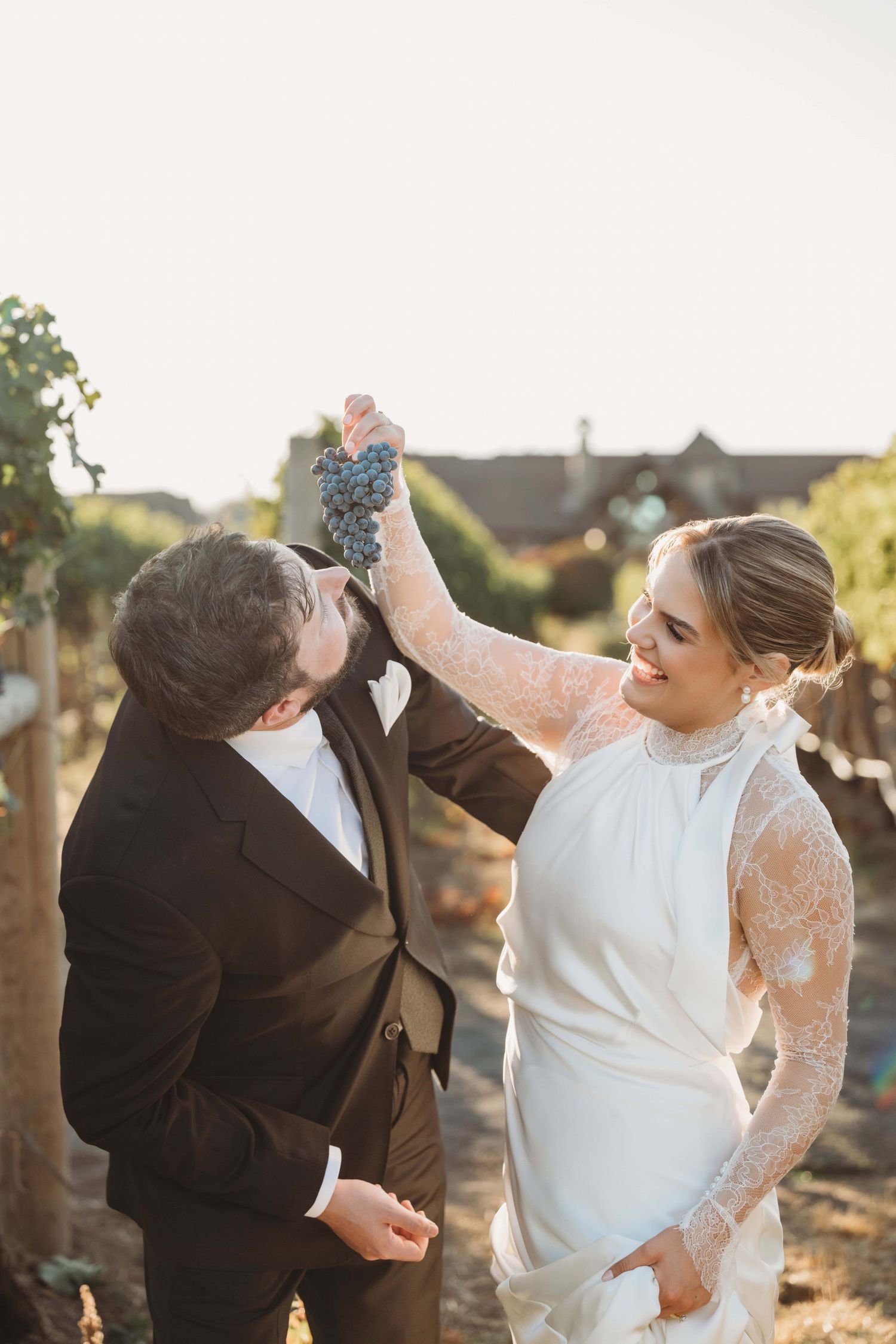 A portrait of a bride feeding her groom grapes in a vineyard at Yellow Hawk Resort, taken by a Walla Walla Wedding Photographer.