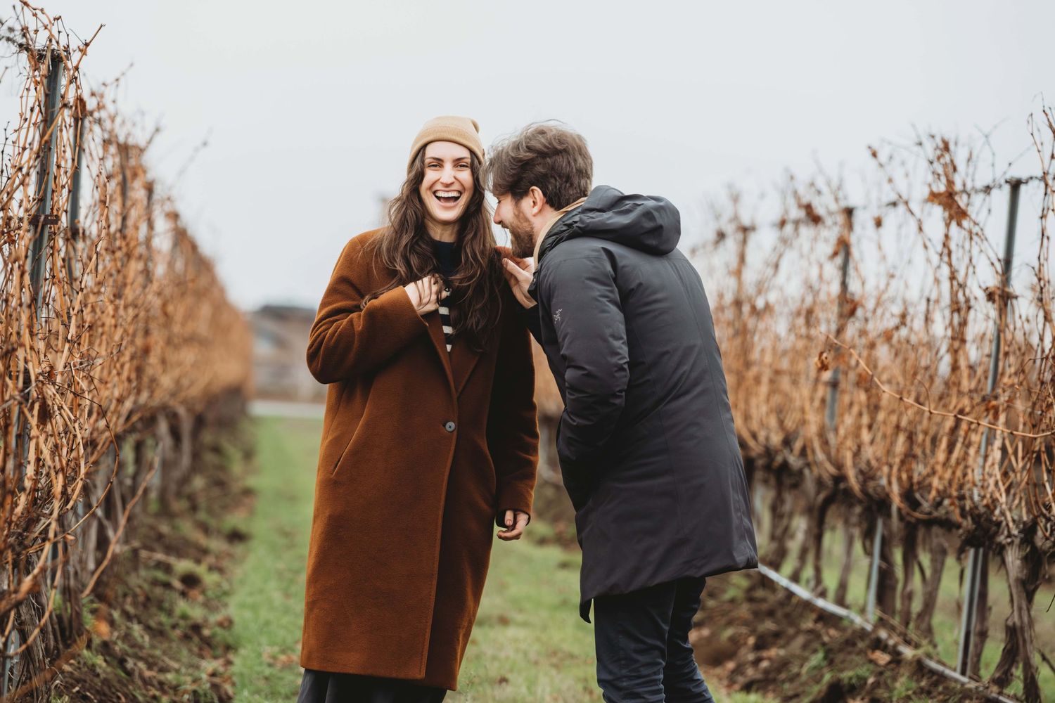 A couple laughing together moments after getting engaged.