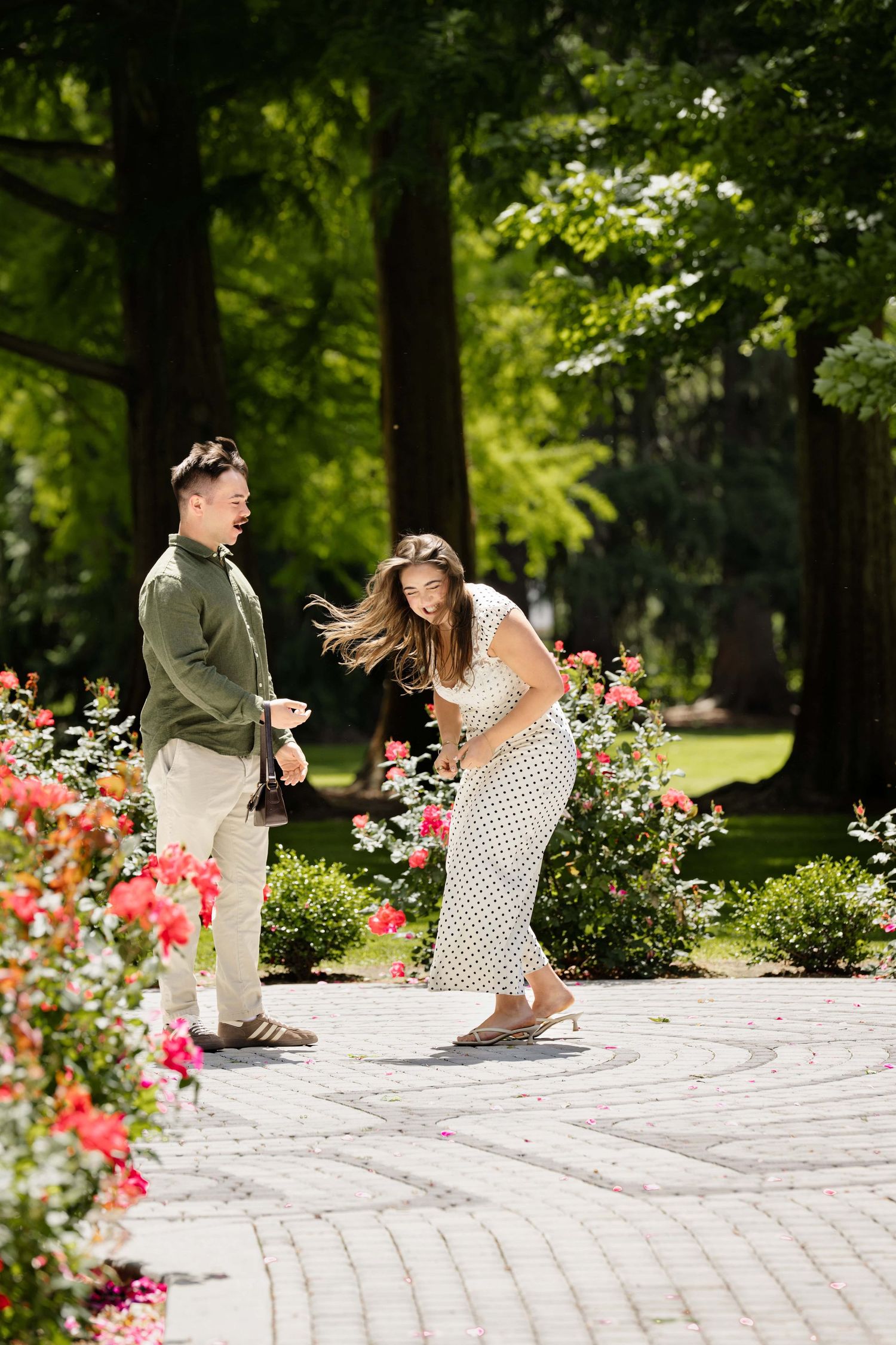 A woman laughing while her new fiancee looks at her happily, taken by a Walla Walla proposal photographer.