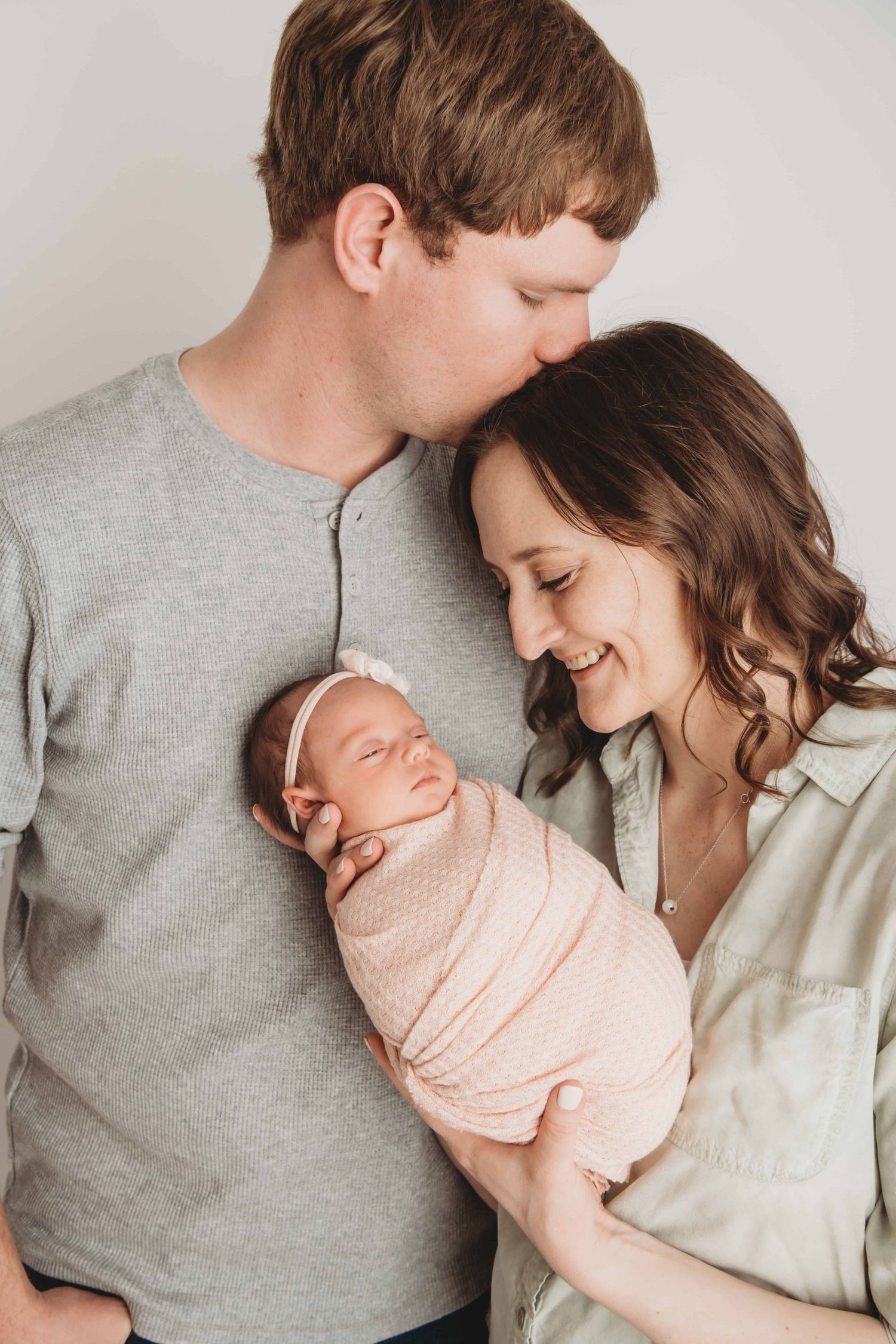 A newborn girl with her parents in studio.