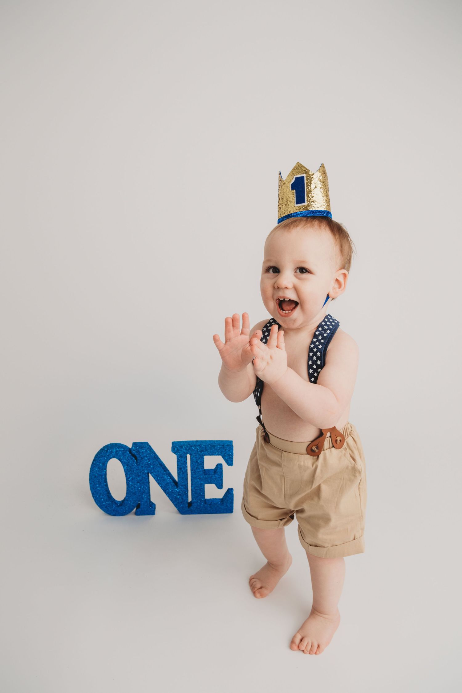 A portrait of a one year old boy clapping his hands at a Walla Walla photography studio.