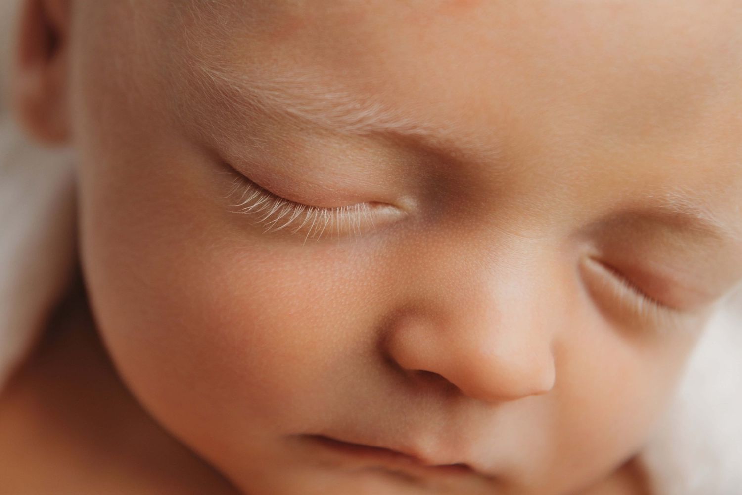 A close up detail shot of a baby with light blonde eyelashes by a Pasco newborn photographer.