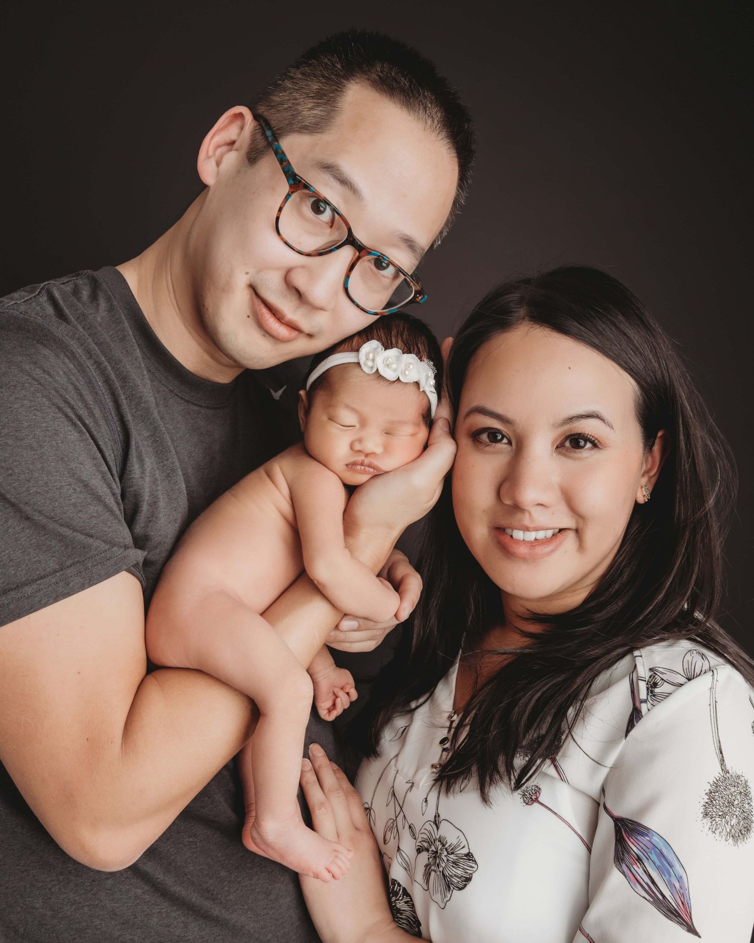 Newborn baby with mom and dad on a black background in Walla Walla studio
