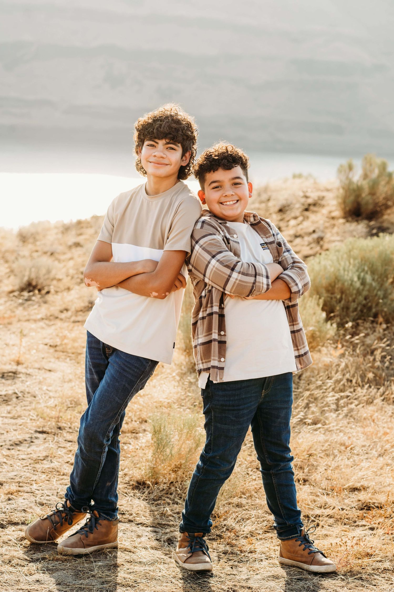 A portrait of two children standing back to back with their arms crossed at Twin Sisters in Walla Walla.