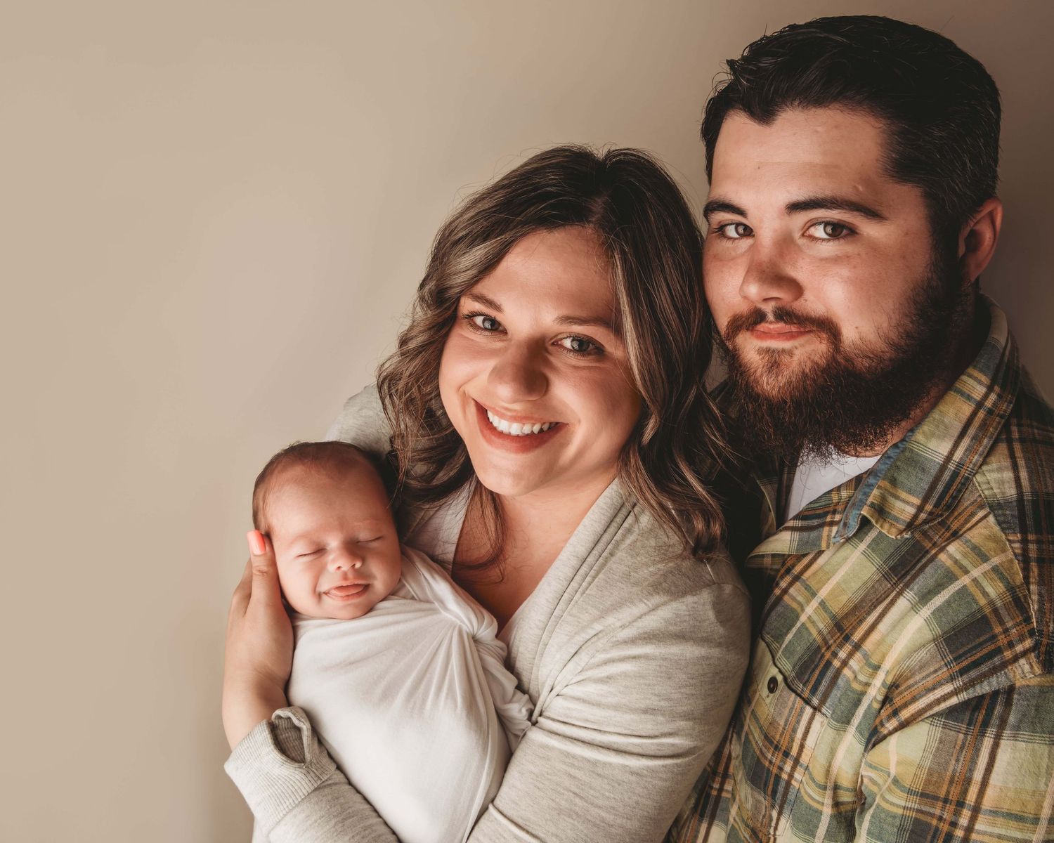 Lifestyle newborn photography in Walla Walla featuring parents holding their newborn baby indoors.