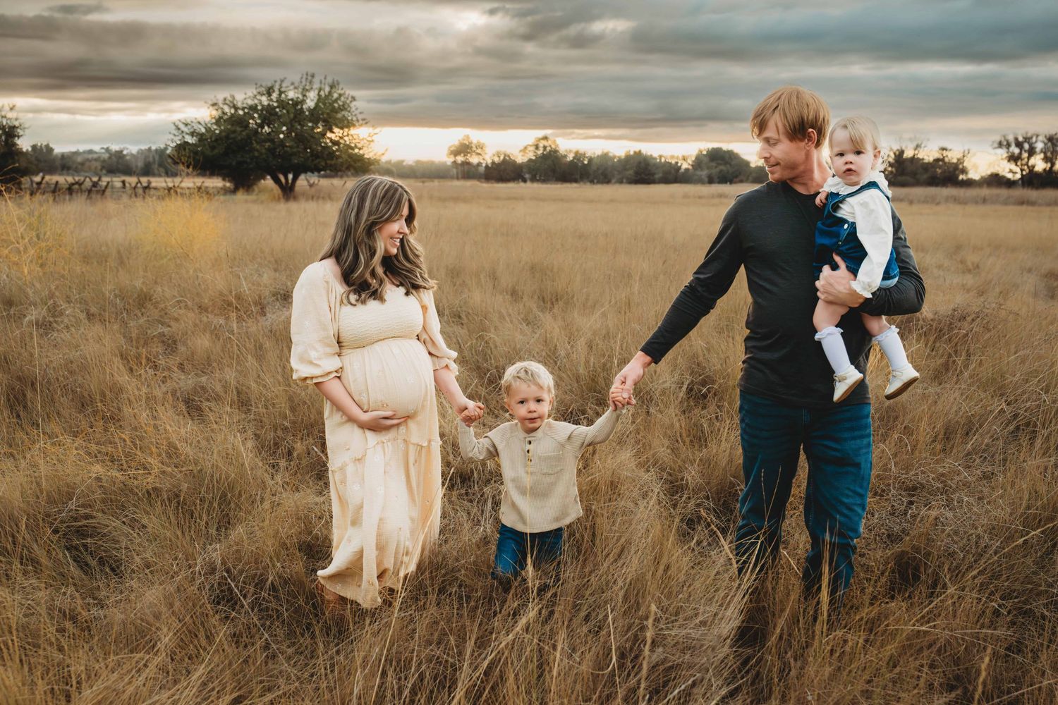 A family walking in a field holding hands during sunset in Walla Walla.