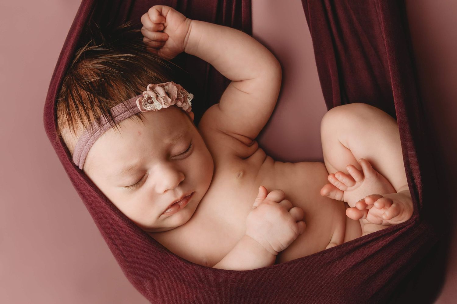 Newborn photography in Walla Walla showing a sleeping baby wrapped in fabric against a soft studio backdrop.