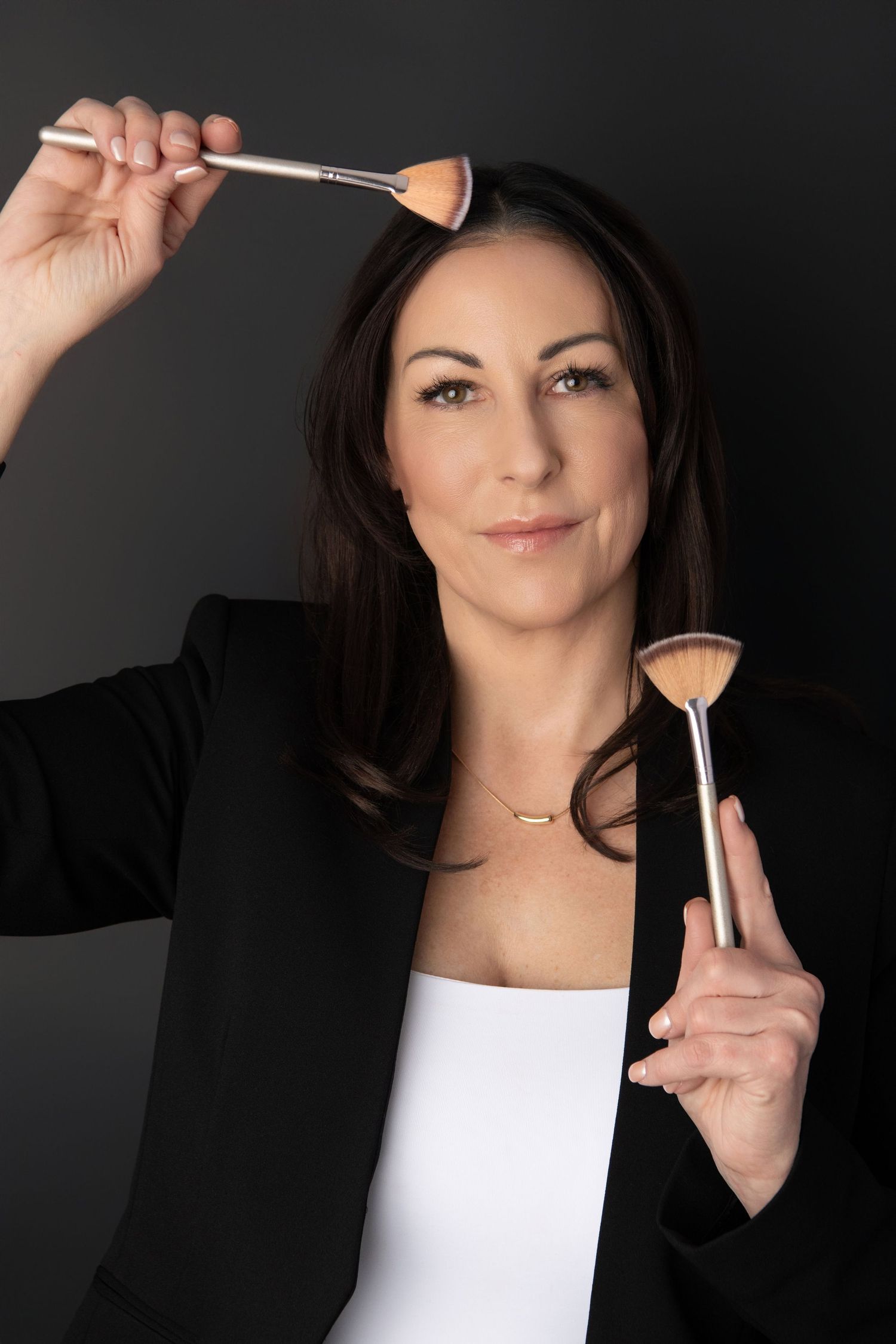 An esthetician in Walla Walla poses with some brushes for a personal branding headshot.