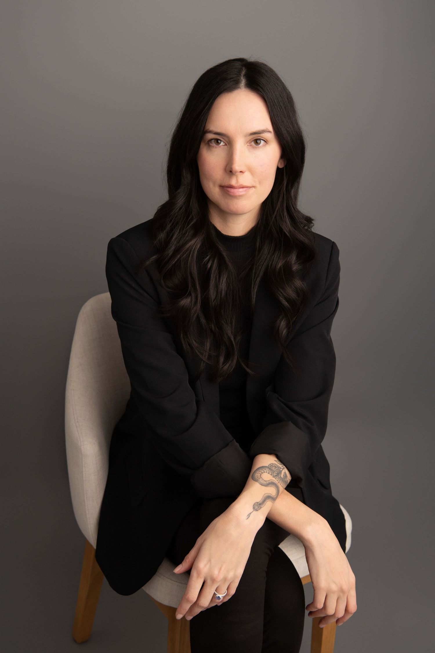 Modern studio headshot of a business professional with relaxed expression.