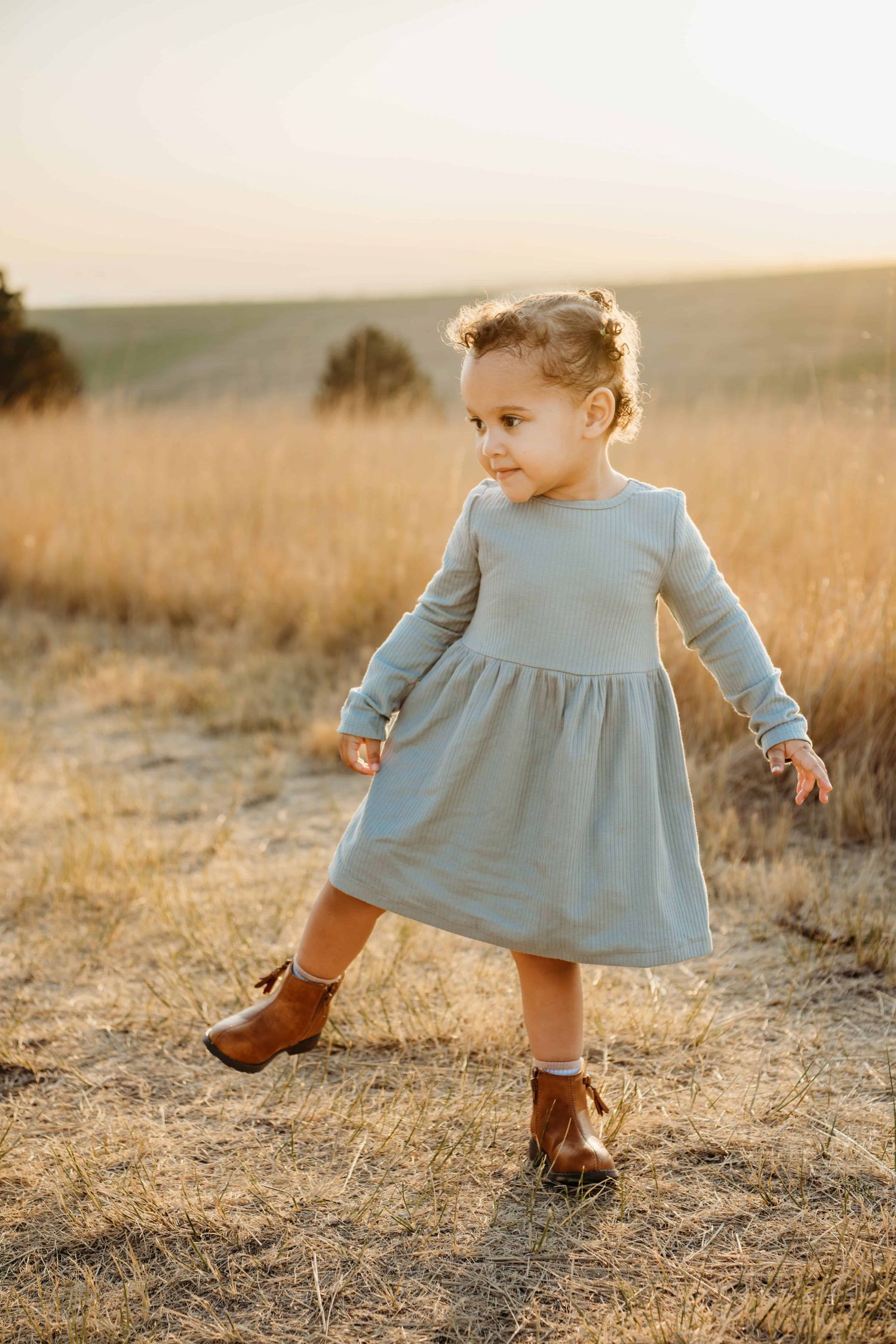 A portrait of a girl dancing wearing a blue dress and boots at Bennington Lake in Walla Walla.