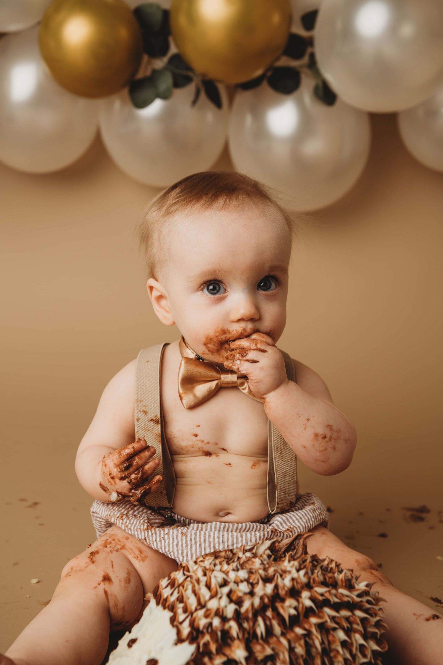 A one year old boy eats his chocolate cake during a cake smash session in Walla Walla.