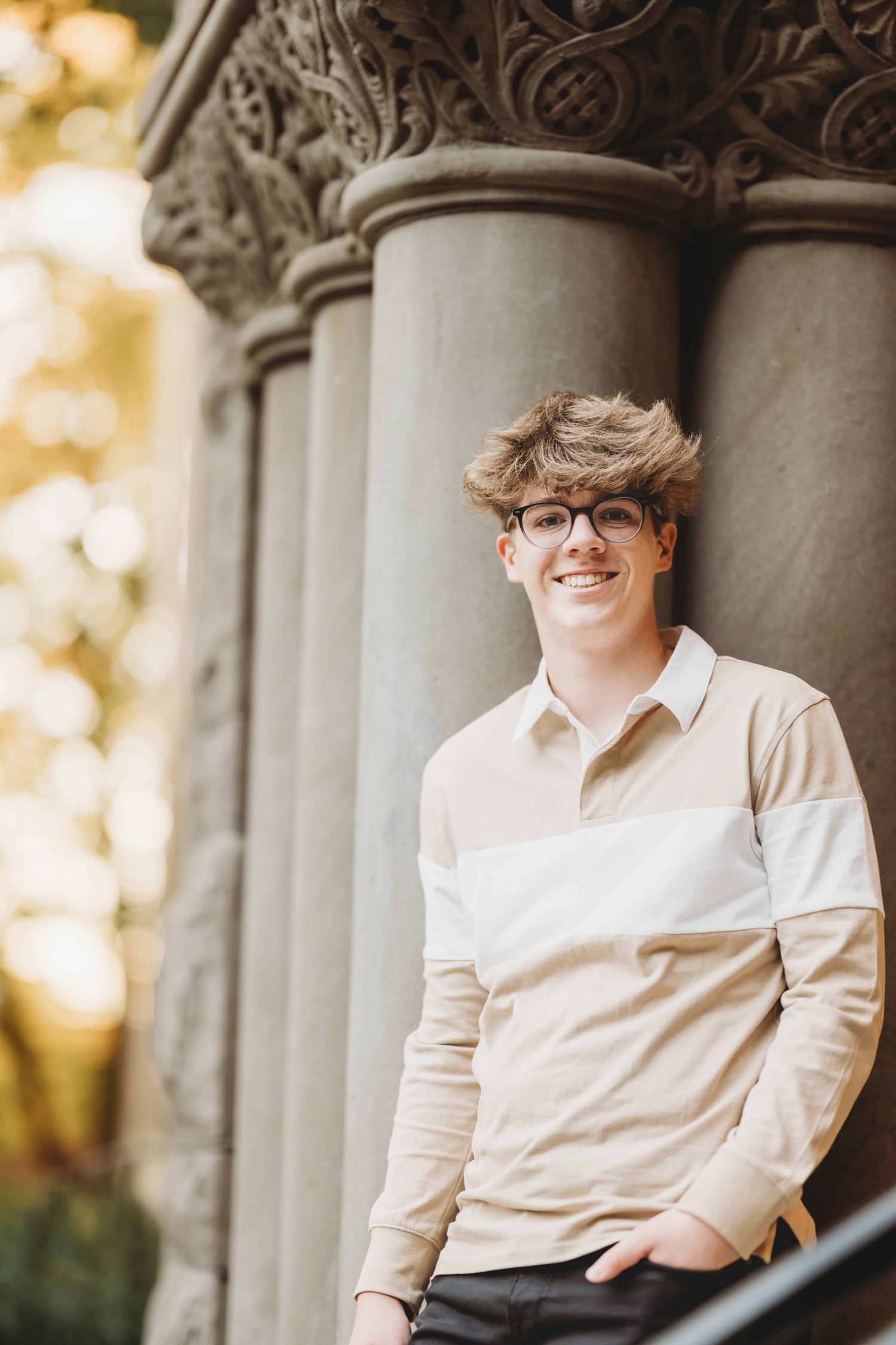 A high school senior standing against some concrete columns at Whitman College in Walla Walla, Washington.