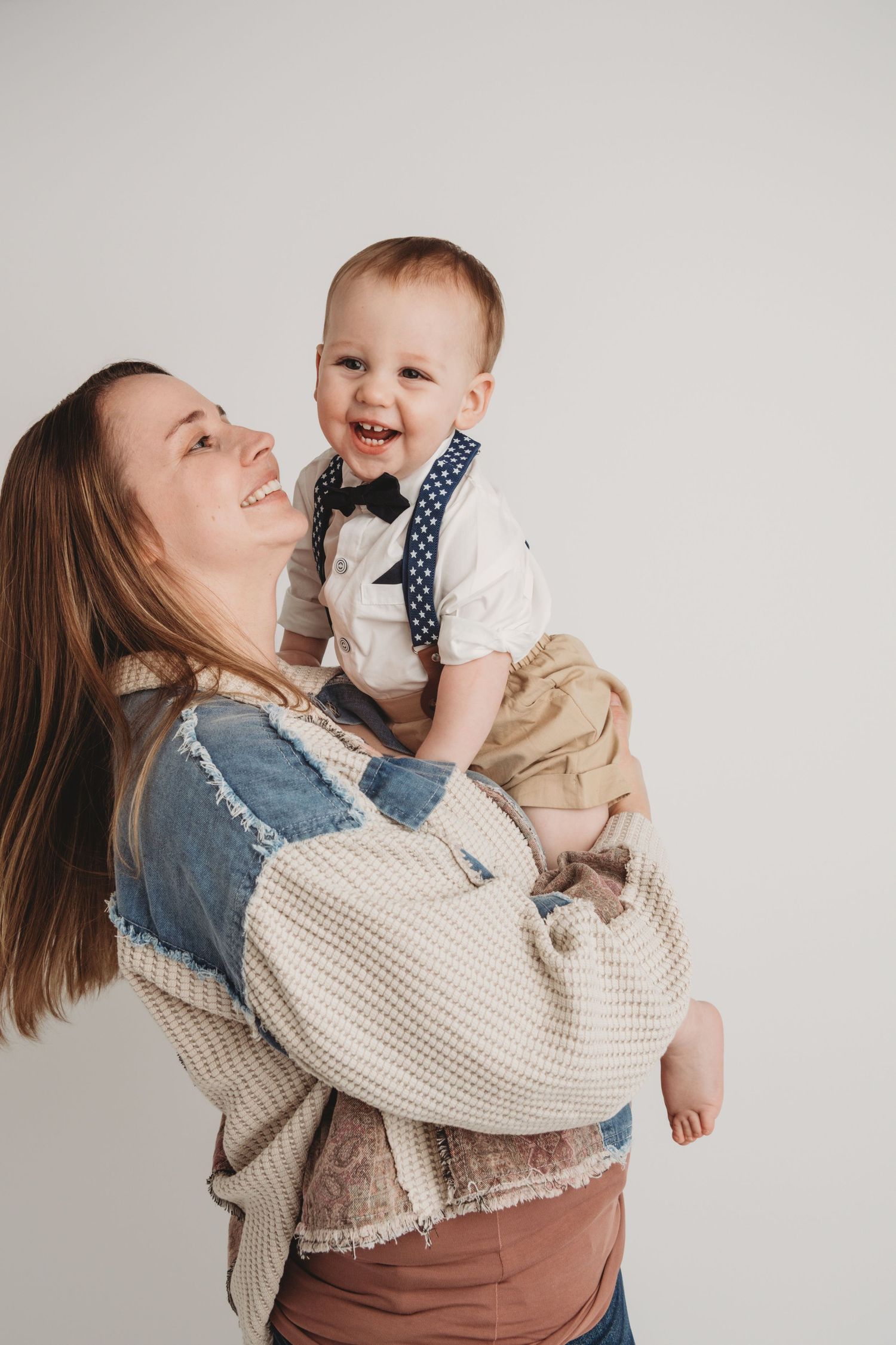 A mom and her one year old boy spinning and laughing in a Walla Walla Photography studio.