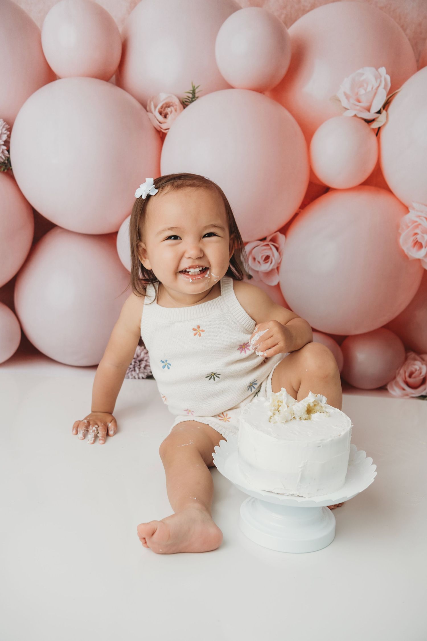 First birthday cake smash portrait celebrating a baby’s one-year milestone during a studio photography session.