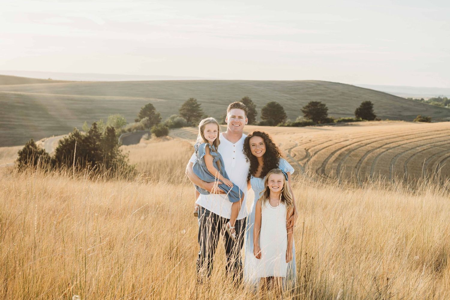 A family standing closely together smiling.