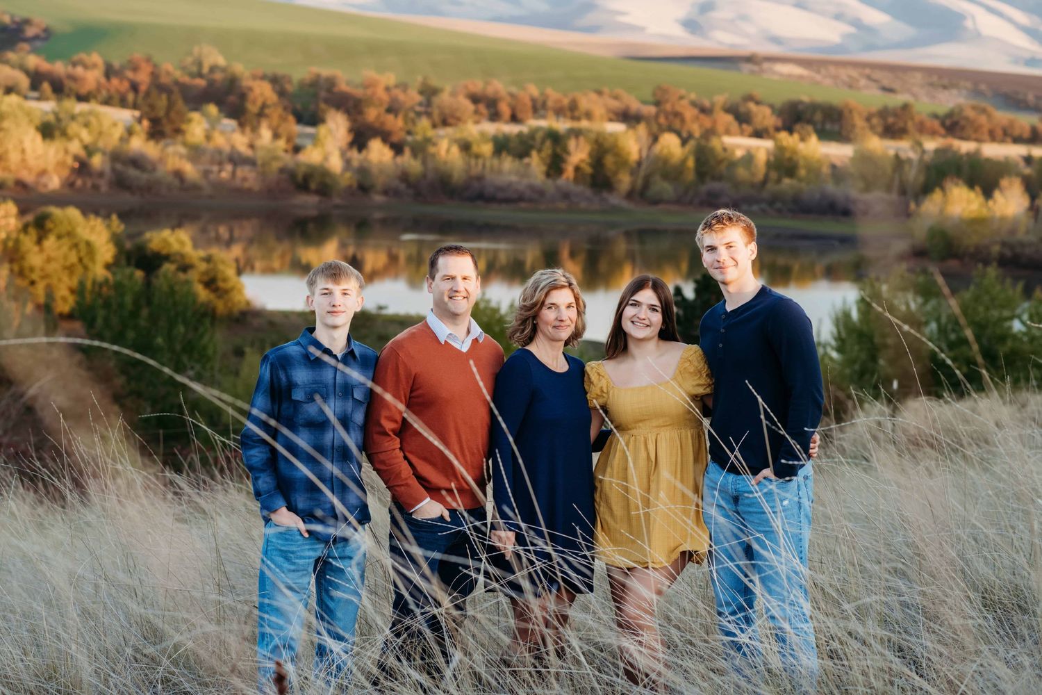 A family of five dressed in fall colors standing in front of Bennington Lake in Walla Walla.