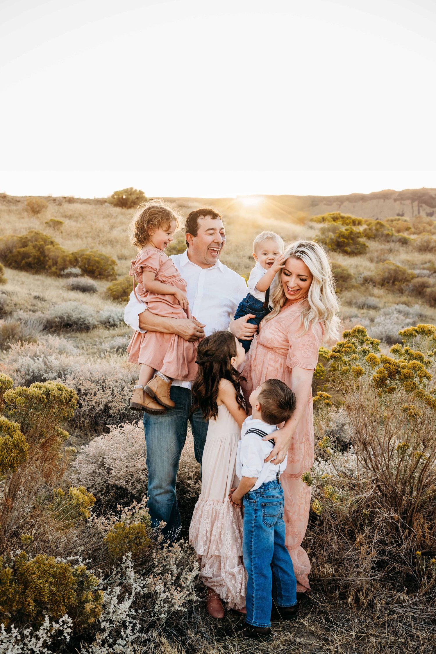 Walla Walla family photography session showing parents and children sharing a joyful moment during golden hour outdoors.