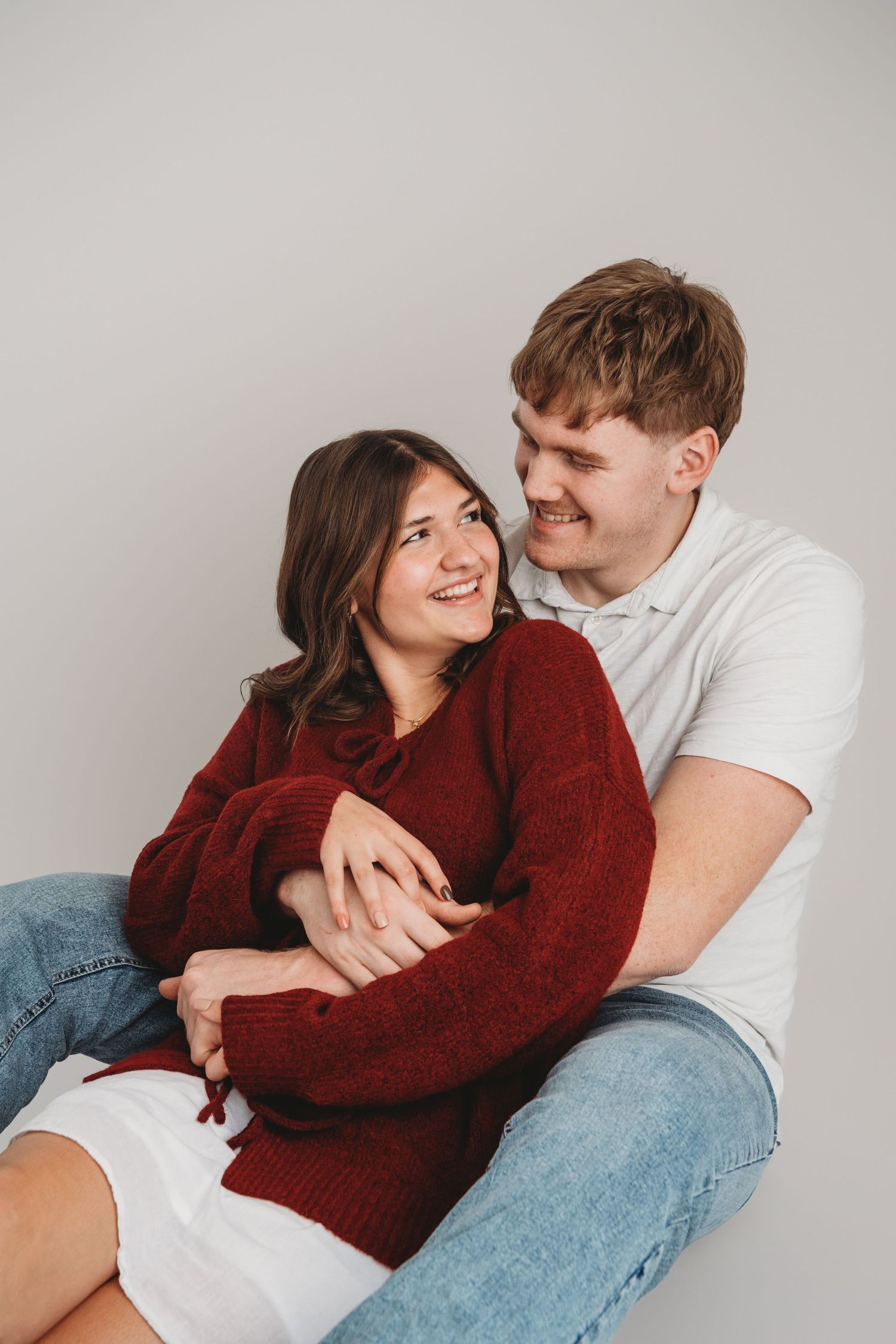 Candid studio couples portrait of a couple sitting together and laughing in Walla Walla