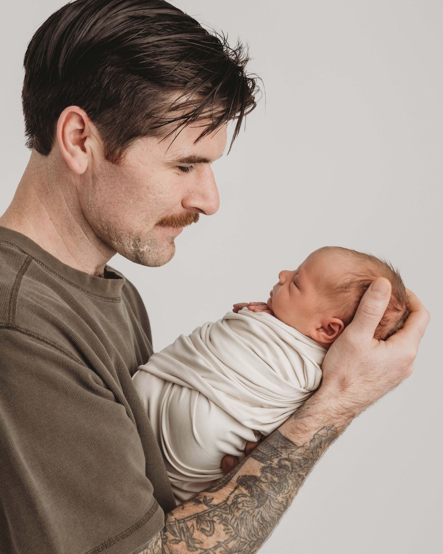 A new father looking and smiling at his newborn son.