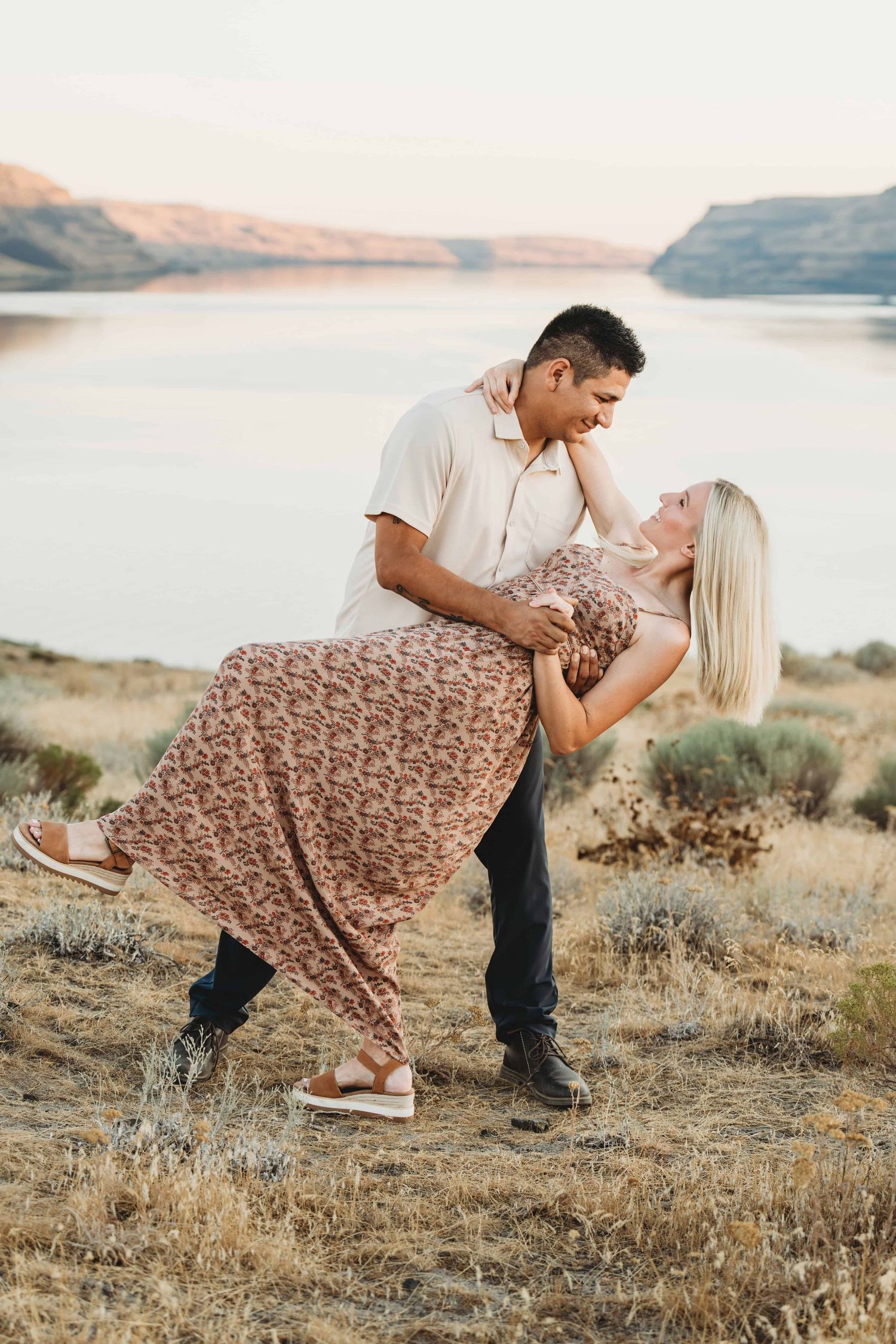 A couple dancing at the top of a hill with the river in the background.