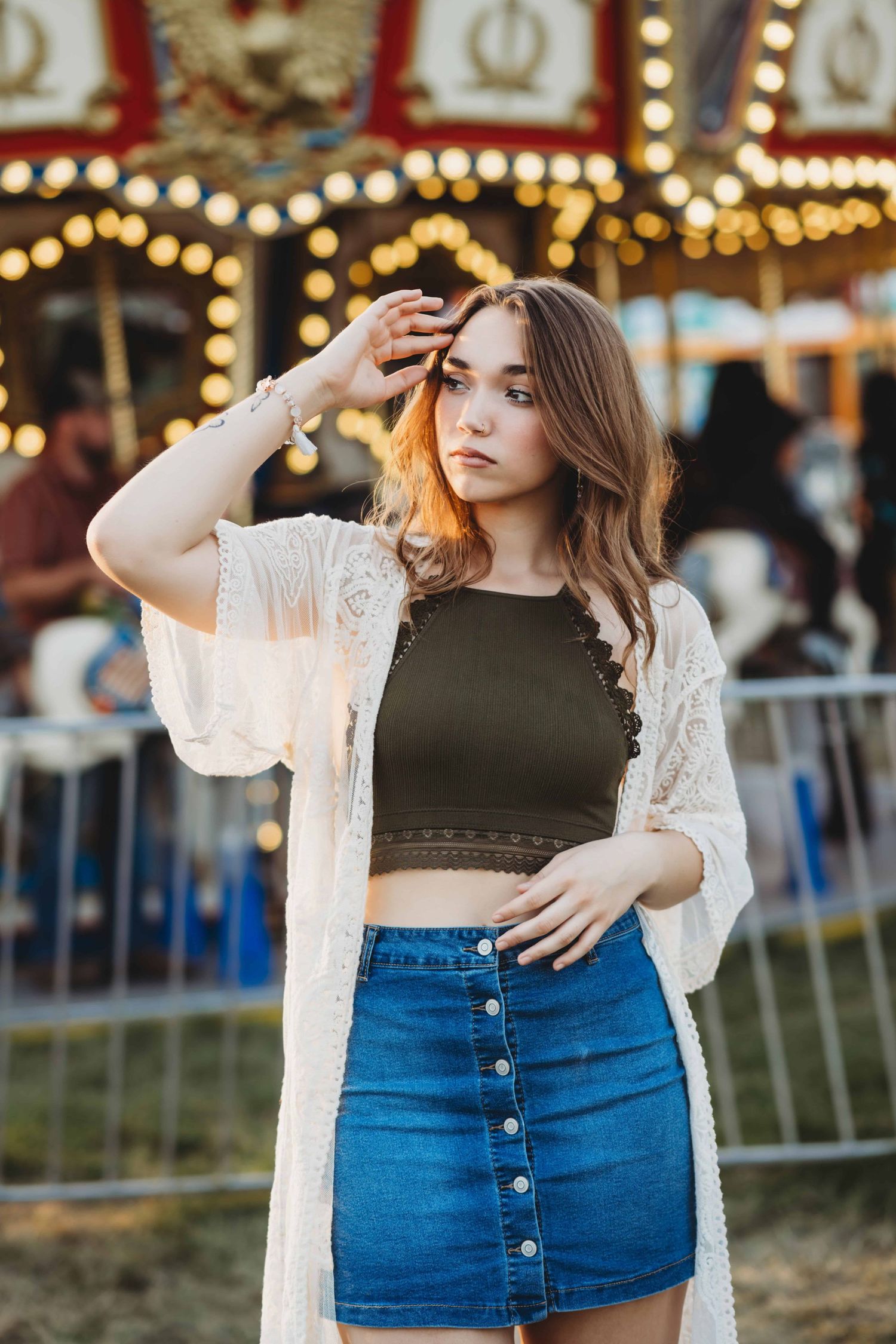 A portrait of a senior standing in front of a carousel at the fair, taken by a Walla Walla photographer.