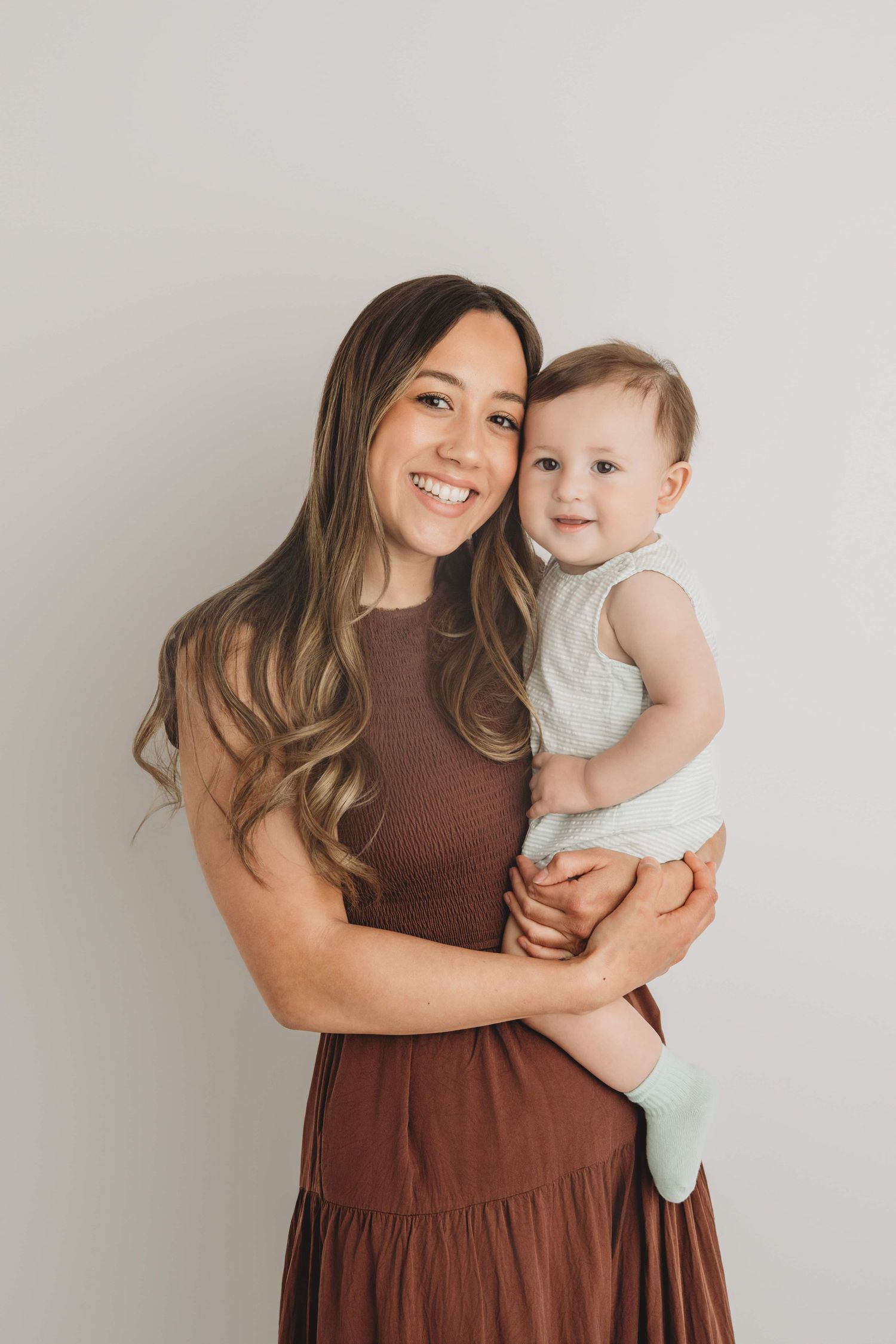 A mom and her baby smiling for the camera at a Walla Walla portrait studio.