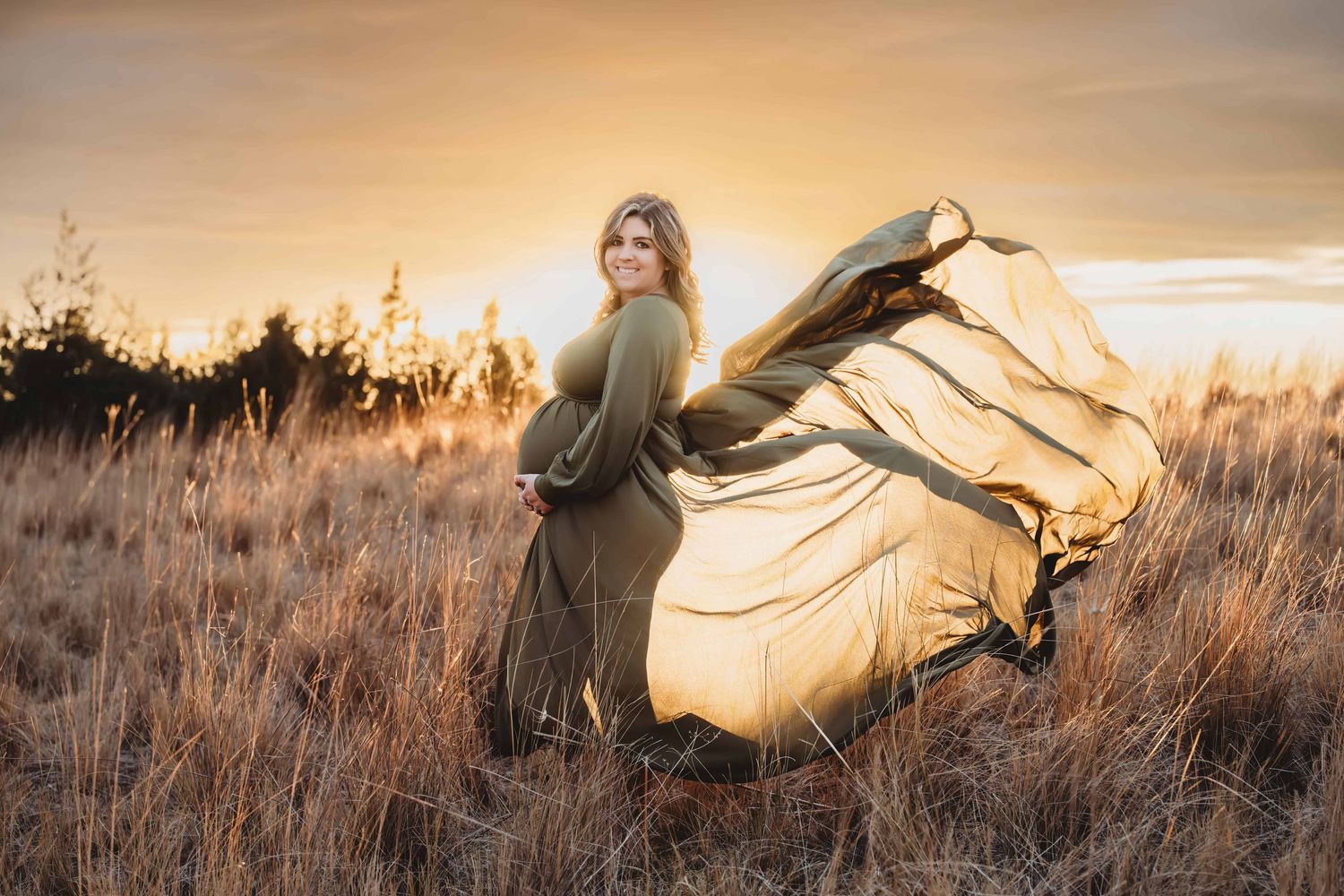 Walla Walla maternity photographer capturing a pregnant woman in a flowing dress during a golden hour field maternity session.